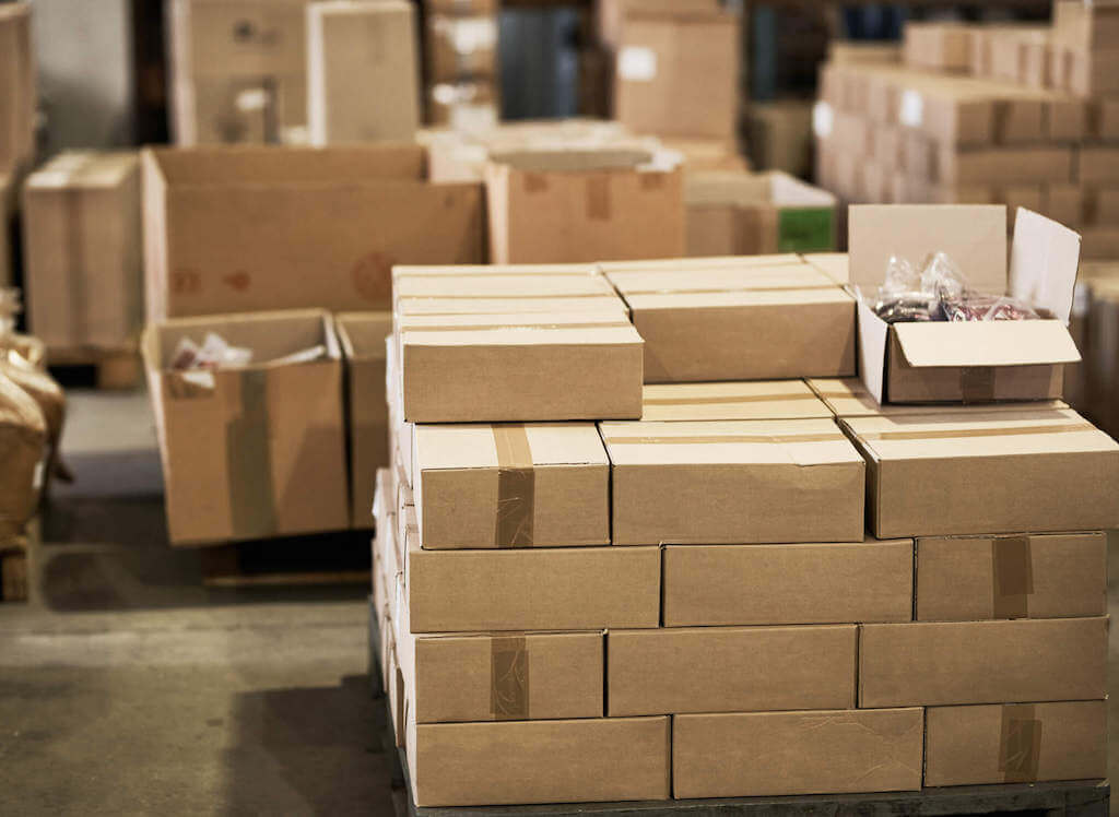 A large pile of boxes wait to be shipped by multiple carriers