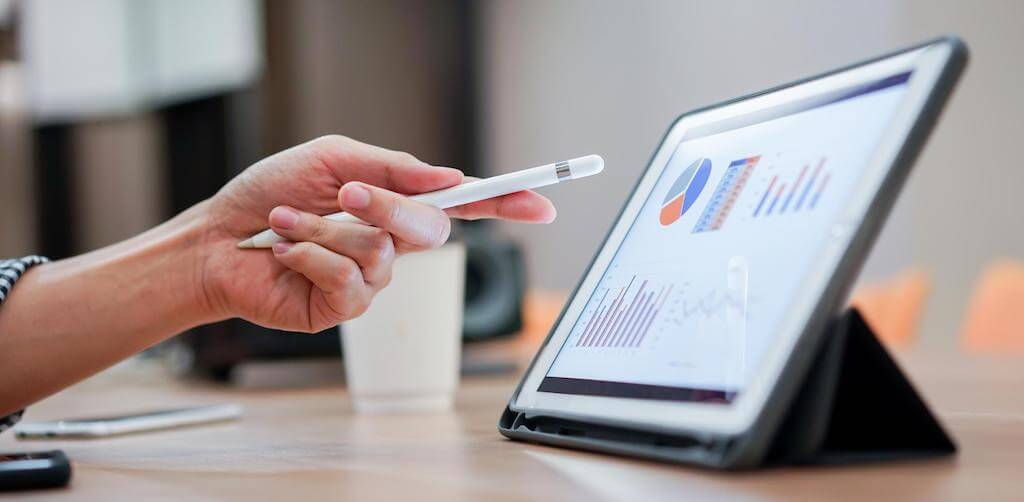 Person pointing at tablet with analytics data