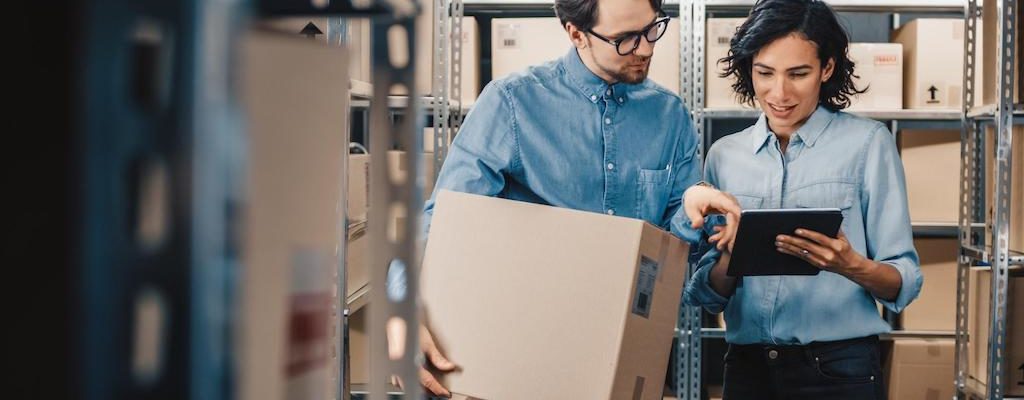 Two employees looking at iPad in warehouse